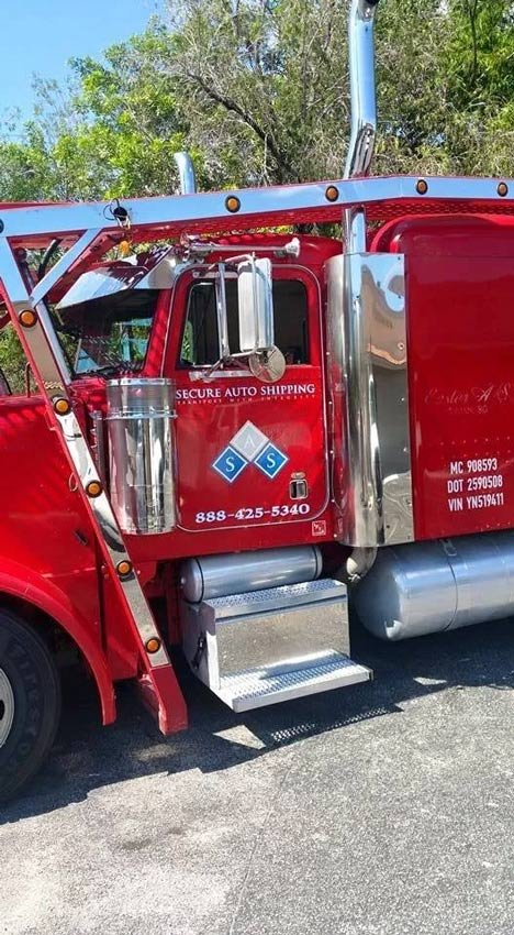 Secure auto shipping red vehicle shipping truck.
