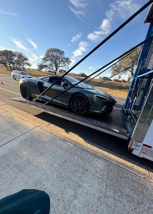 Supercar being loaded into a hard-sided enclosed trailer
